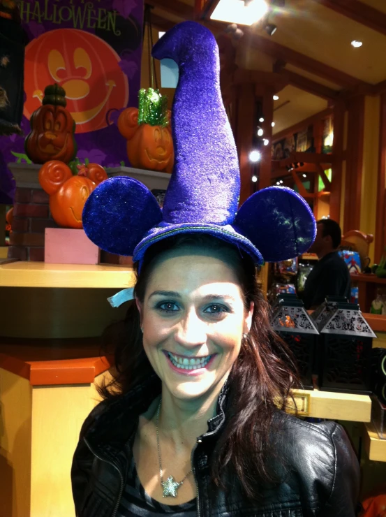 a young woman wearing a purple and black witches hat