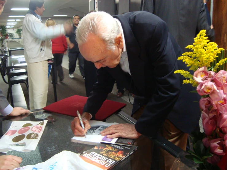 a man signing soing to someone at a table