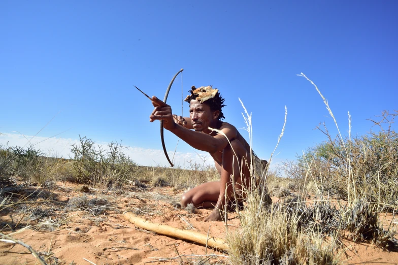 a person kneeling down in the dirt with an animal