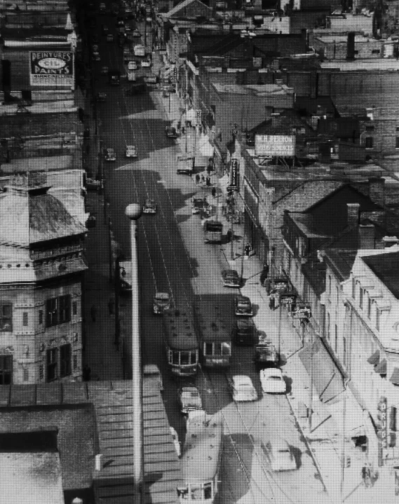 black and white pograph of cars in traffic in an urban area