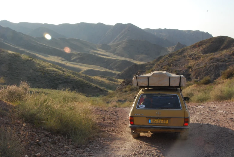 an image of a vehicle parked on the side of a dirt road