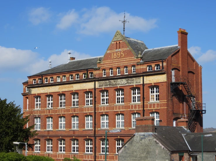 a large brick building has two clocks on top of it