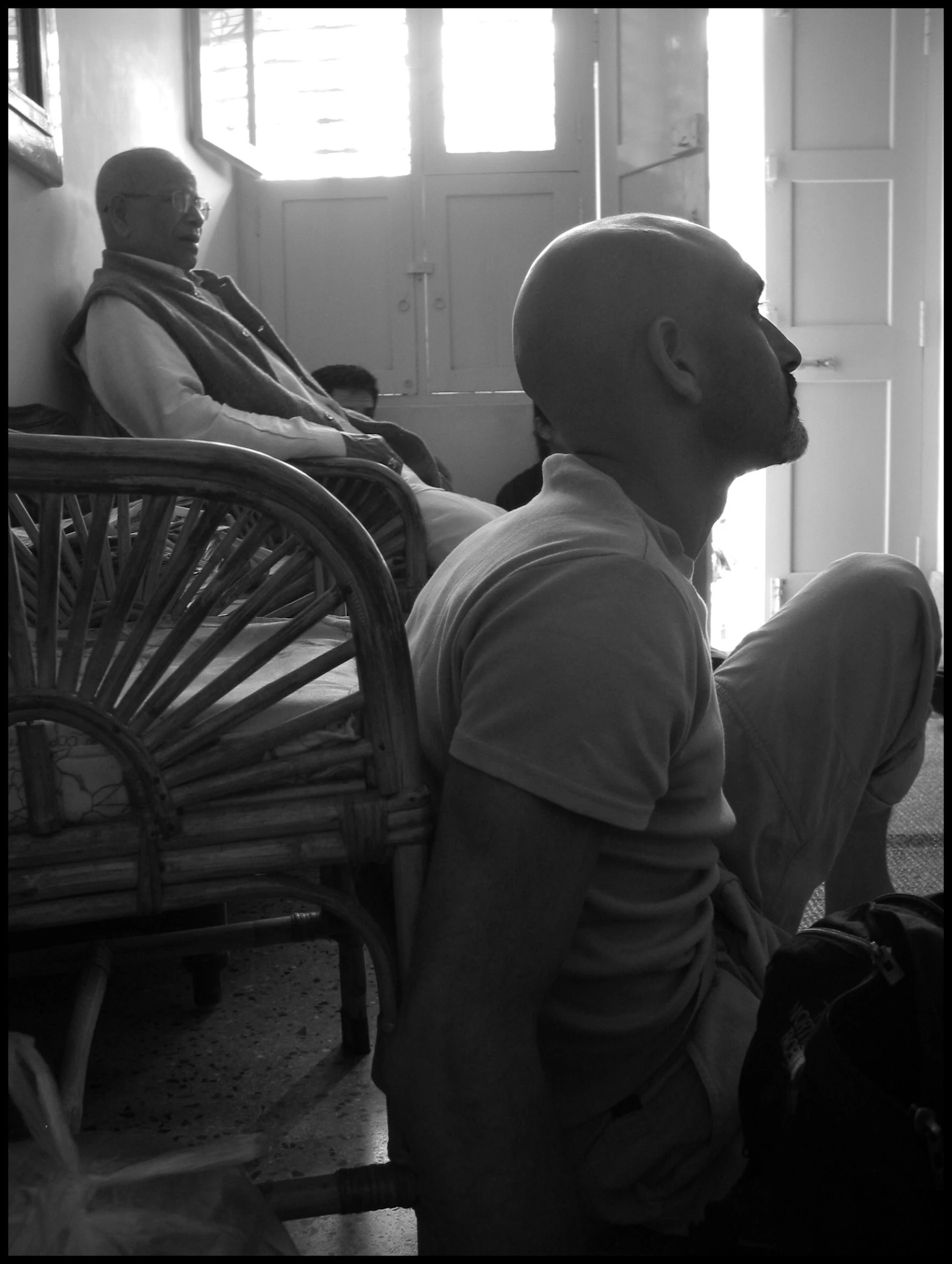 people sit in line with the man in a white shirt and hat