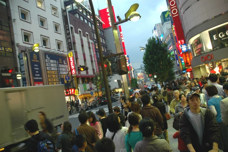 a crowd of people walking down a busy street