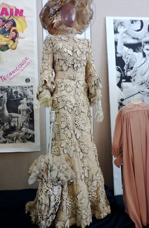 a dress, veil, mannequin and hat sitting on display