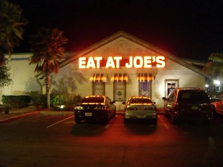 a view of a restaurant with the words eat at joe's glowing brightly