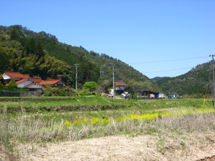 a small field with lots of trees and hills in the background