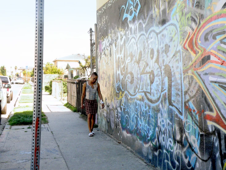 a woman standing in front of a graffiti covered wall