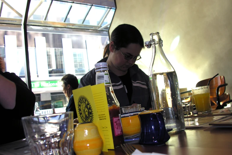 a woman in glasses is filling up glasses on the table