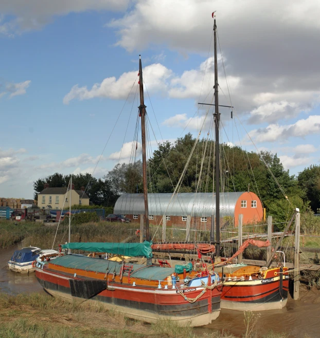 three boats are sitting in the mud by a building