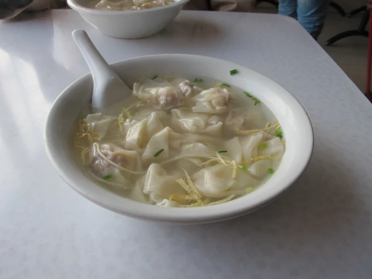 soup in white bowl and bowl on table