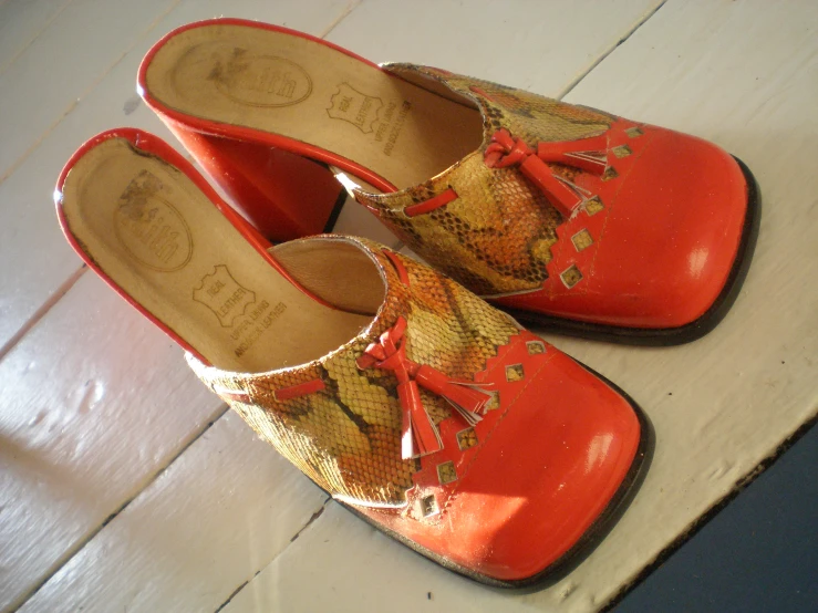 a pair of red shoes with snake skin on them