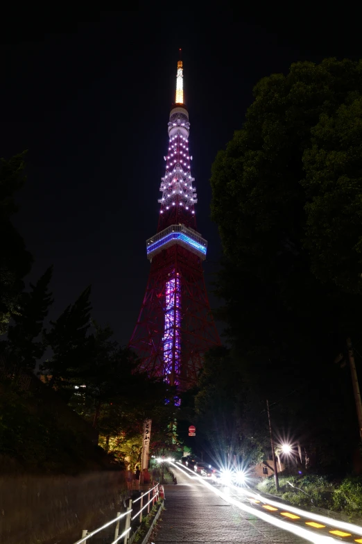 a street with cars in front of a very tall structure