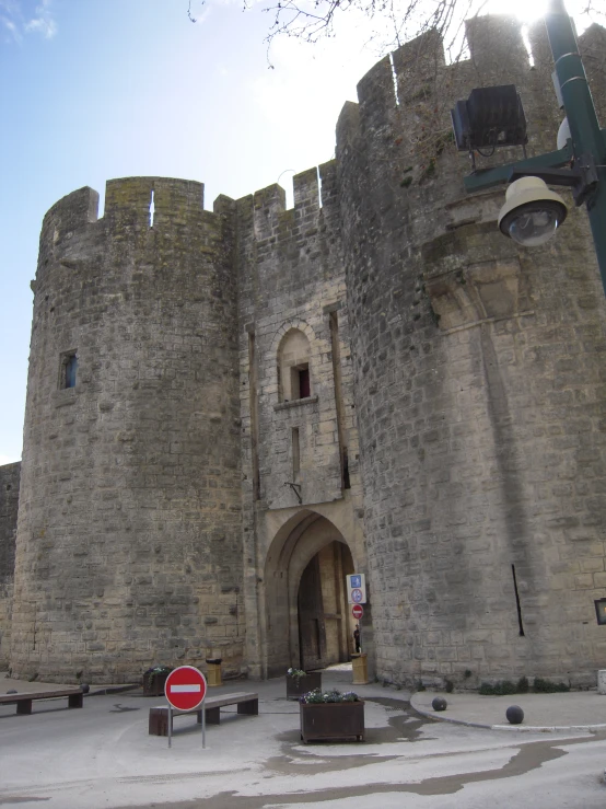 a tall stone castle with a red stop sign