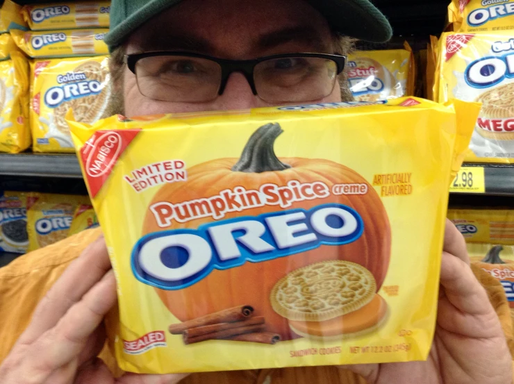 a person holding up a box of oreo pumpkin spice cookies