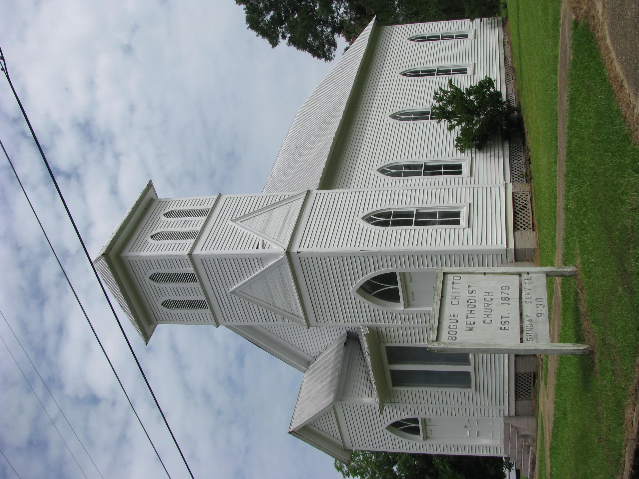 an old white church building with an arched doorway