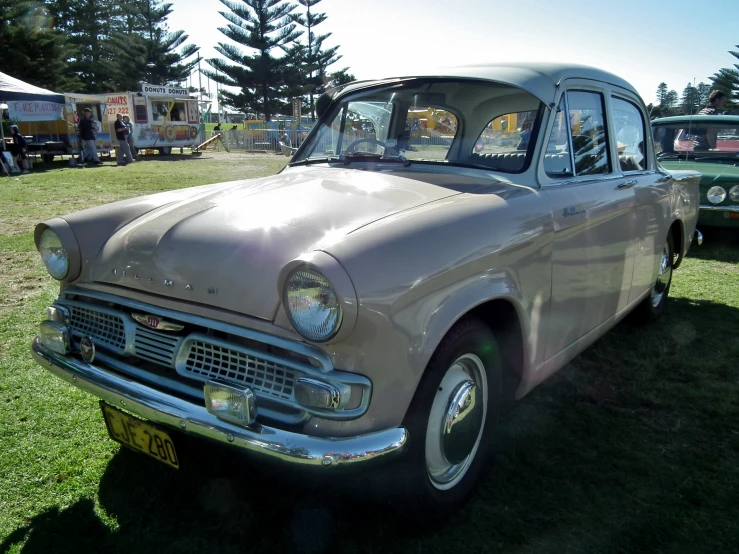 an old car is parked on the grass next to other cars