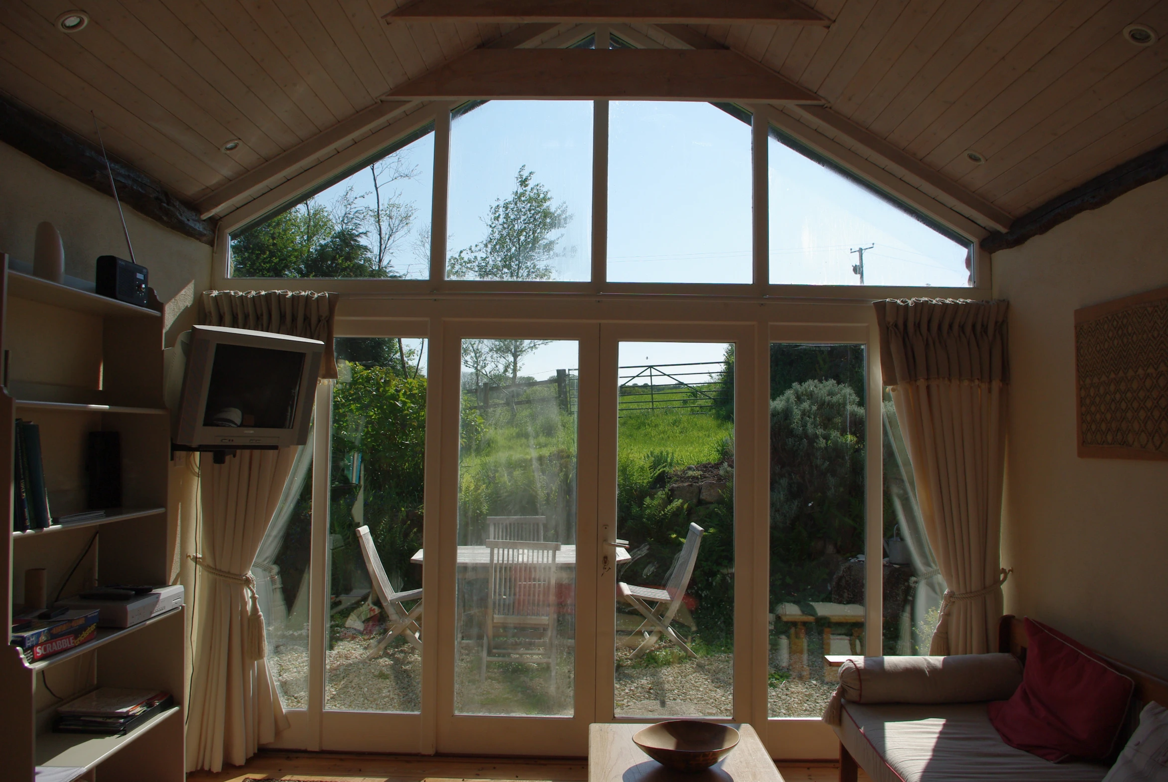 a room with several windows and wooden furniture