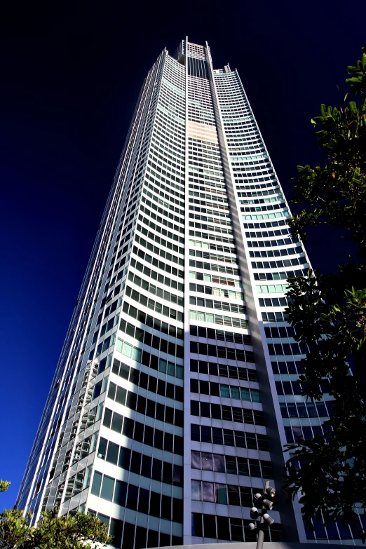 an office building surrounded by trees, a street sign and trees