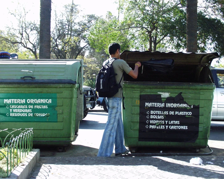 a woman that is standing next to some trash cans