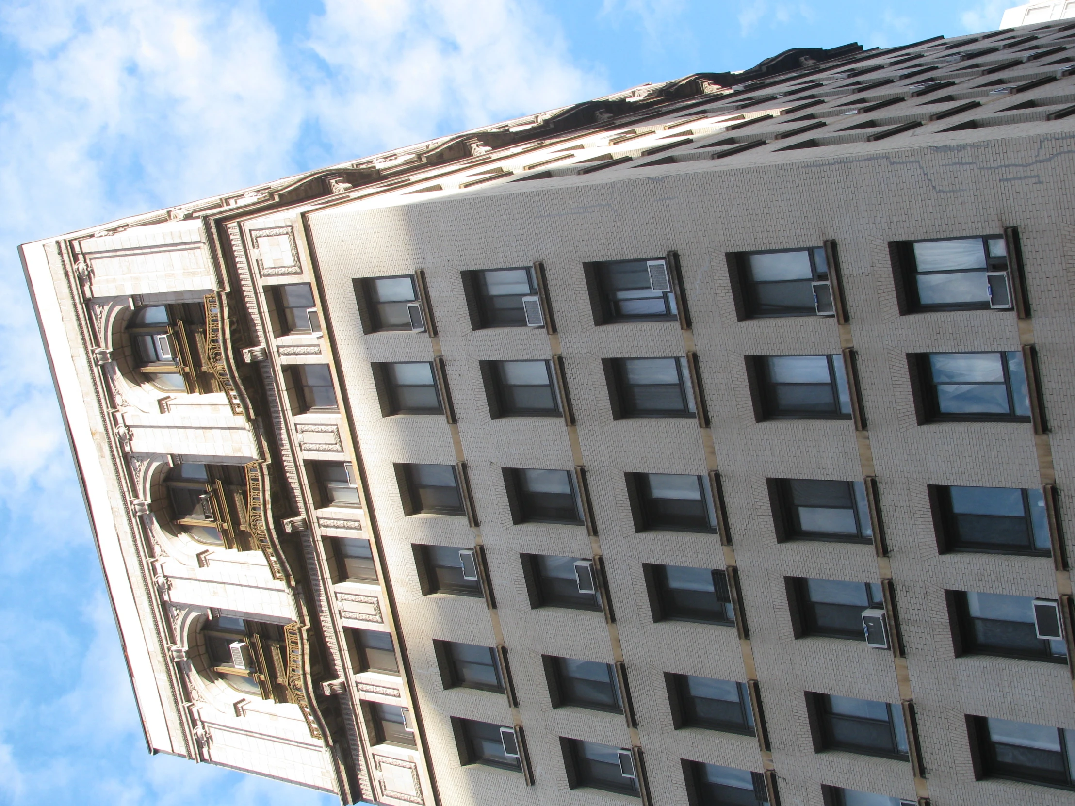 the sky above a very tall building with many windows