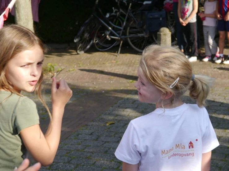 two girls are in the grass near people