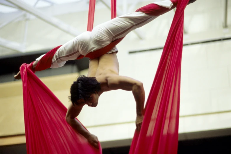 a young man does aerial acrobatics on one leg and on one hand