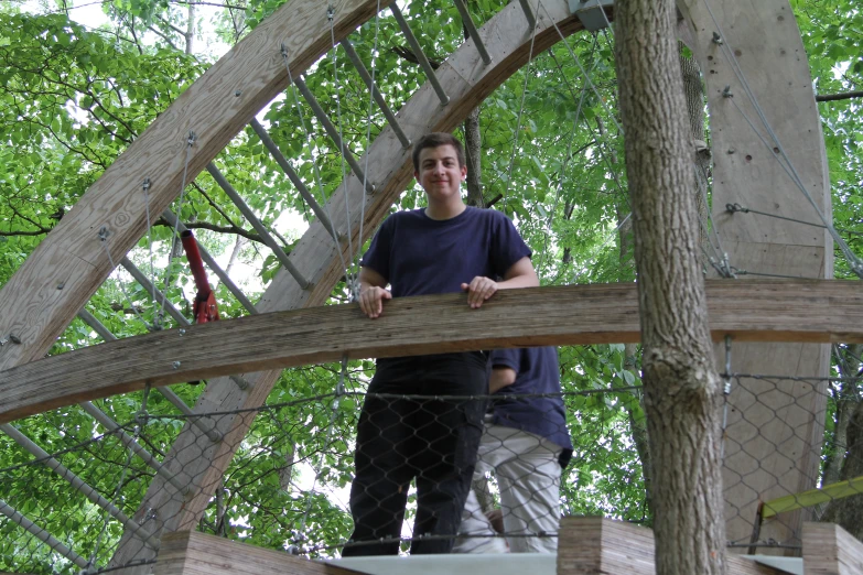 two people standing on a ladder in a tree house