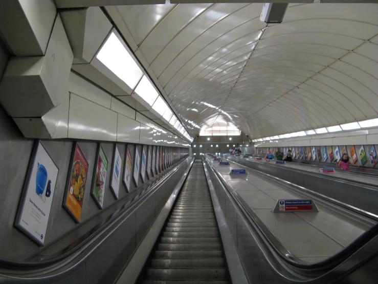 an escalator going down a long and empty subway