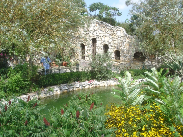 several people are sitting by an old stone building