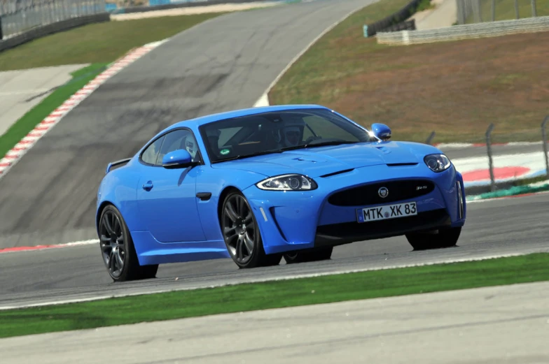 the blue sports car drives on a race track