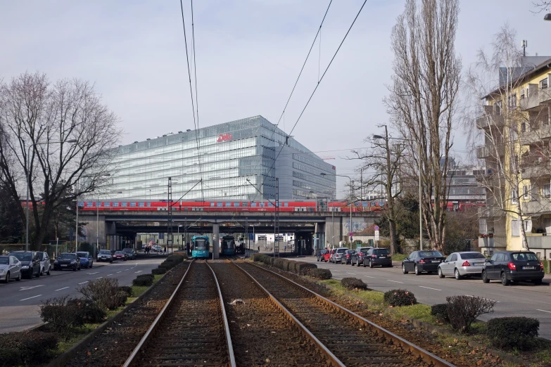 many cars on the tracks near a large building