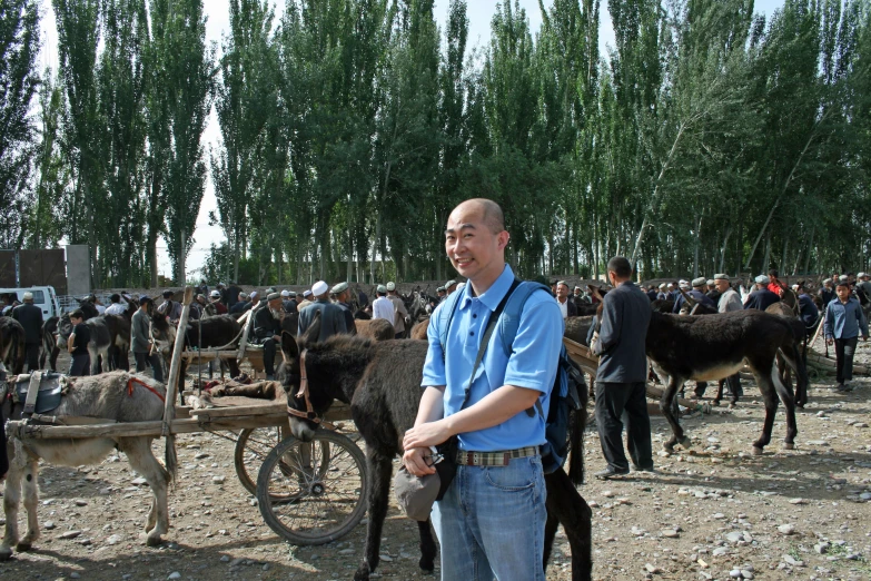 a man standing in front of cows and machinery