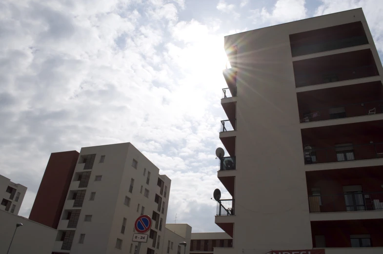 the sun shining through a very tall building