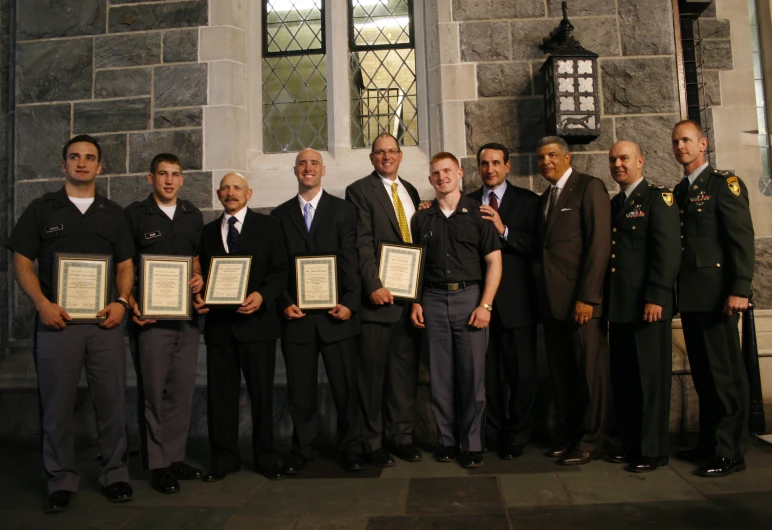 men are all in suits standing together with plaques