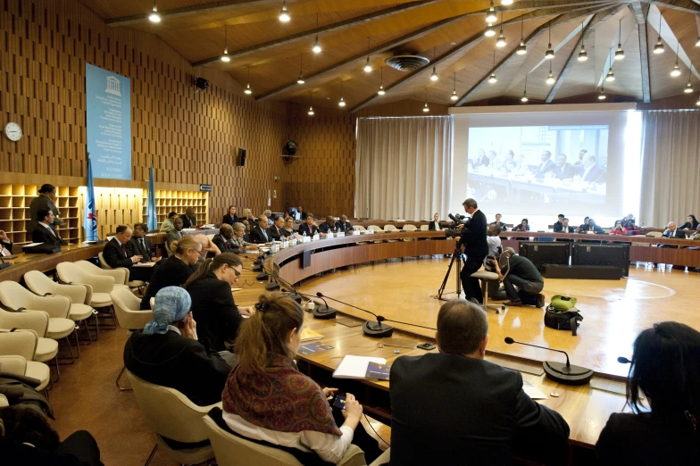 people sitting around a conference room on chairs