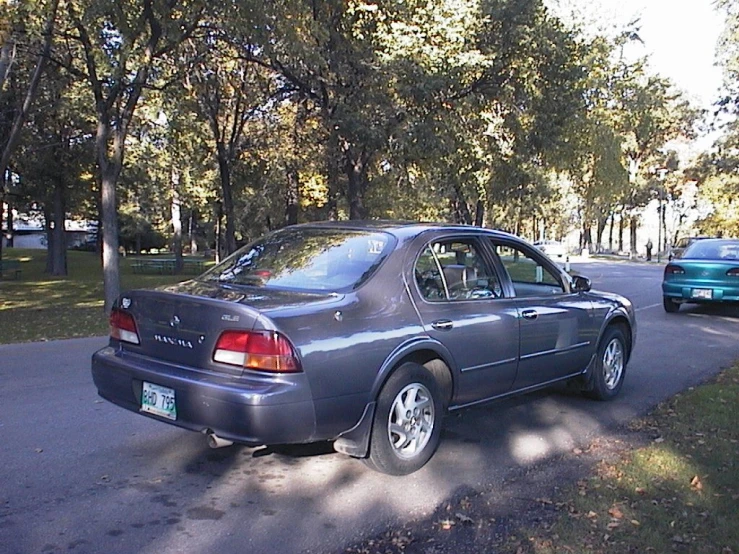 this is a car parked in the street near a stop sign