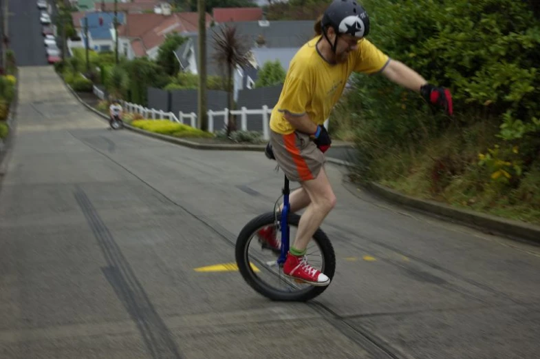 the boy in yellow shirt rides his tricycle down the street