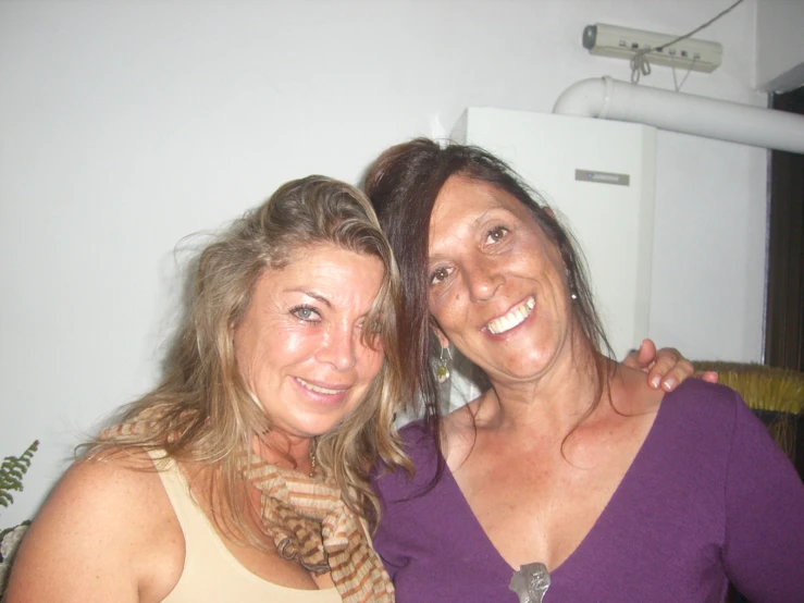 two woman standing together smiling for the camera