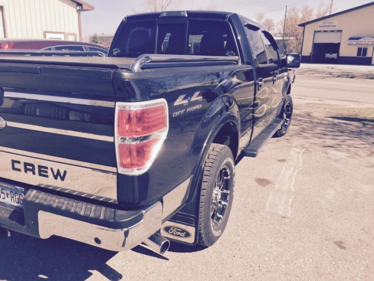 a black truck is parked outside in a lot