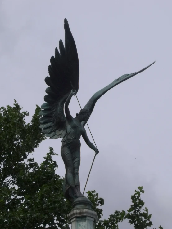 a bronze statue of a woman holding an arrow and a bow