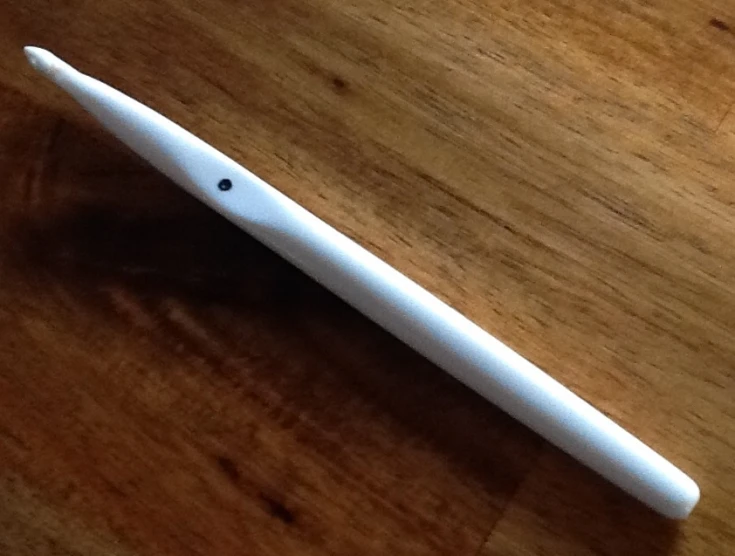 a white, wooden surface has a pen in the middle