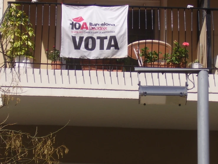 a white banner is hanging from a balcony