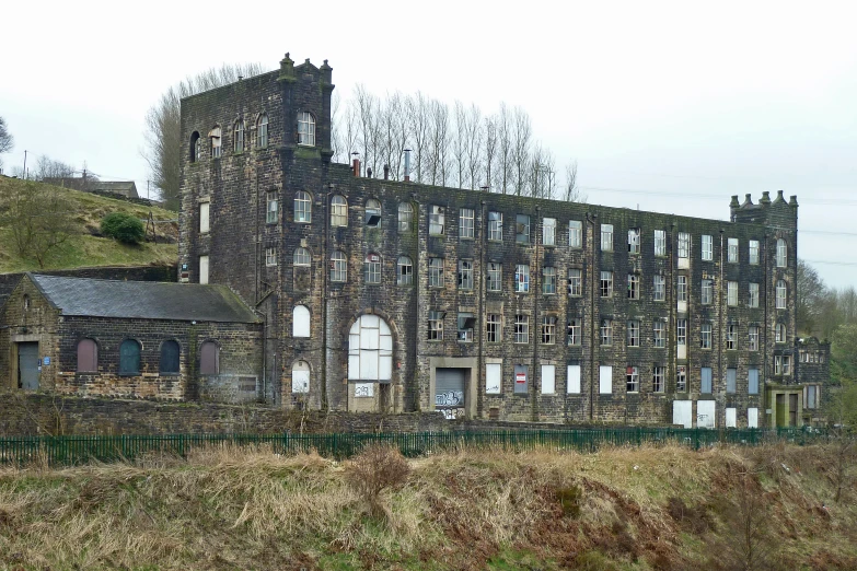 an old brick building that's on a hill in the middle of nowhere