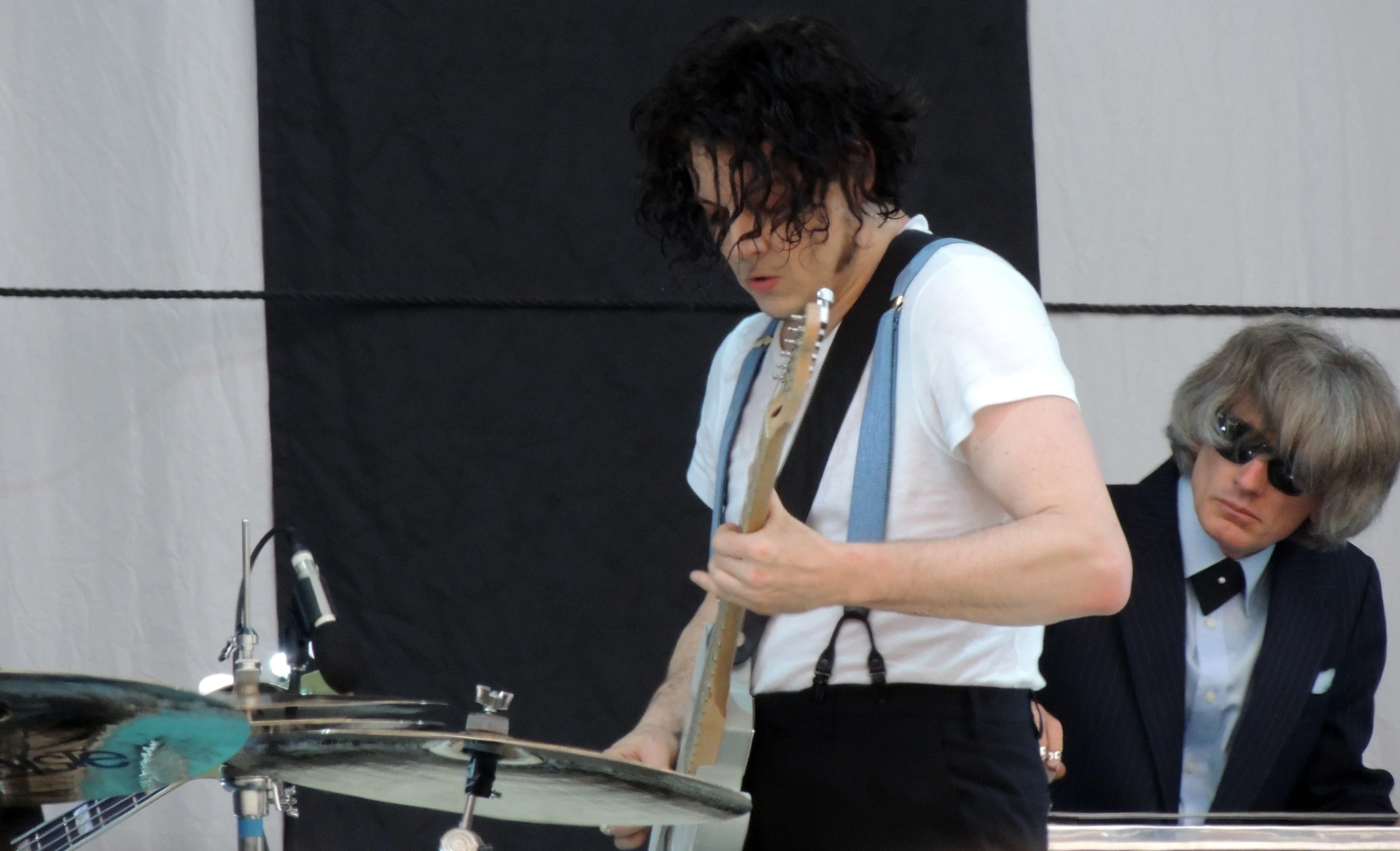 a man with dark hair plays a musical instrument