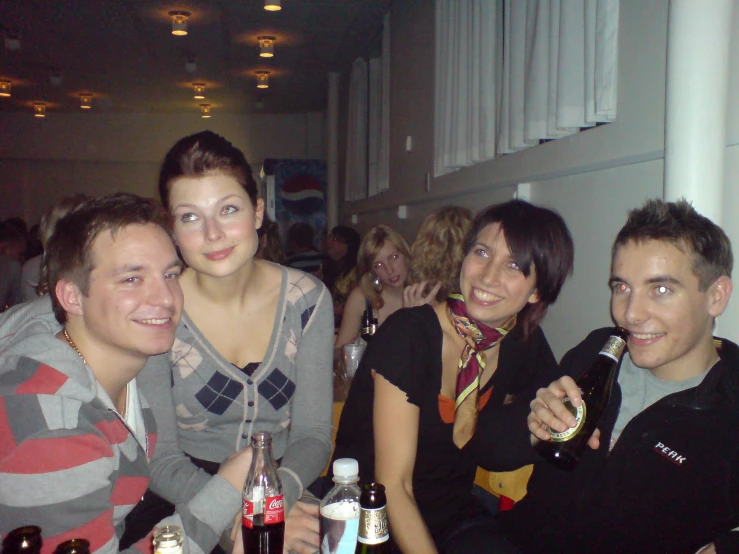 three men and two women sitting together at a bar