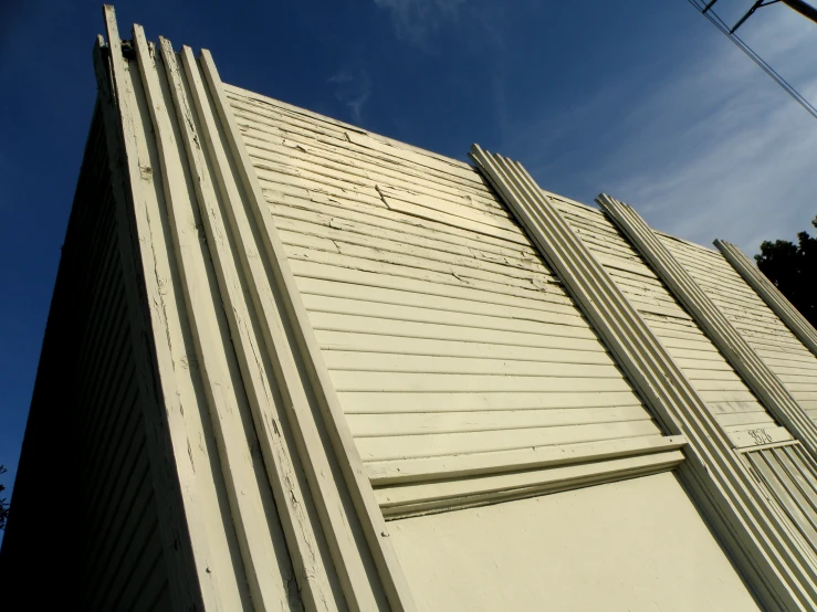 a tall white building next to a telephone pole