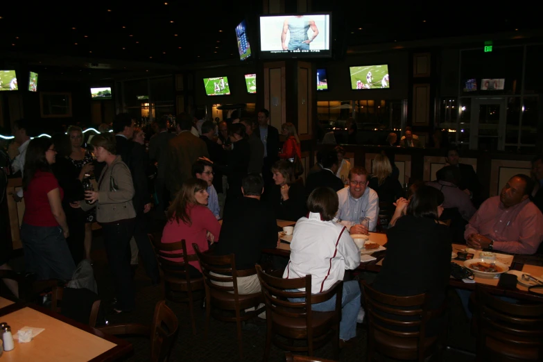 a group of people standing and sitting around tables