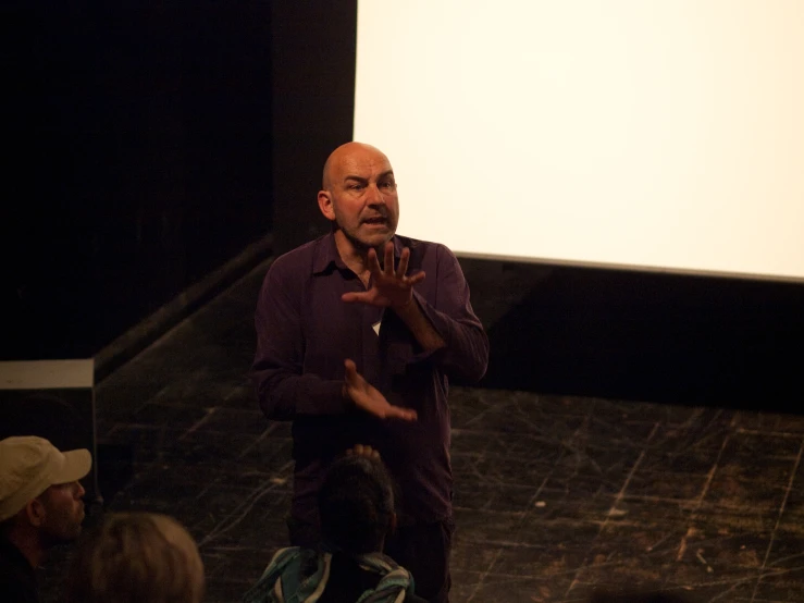 man standing on stage in front of an audience