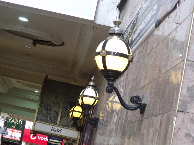 two lamp shades attached to the side of a building